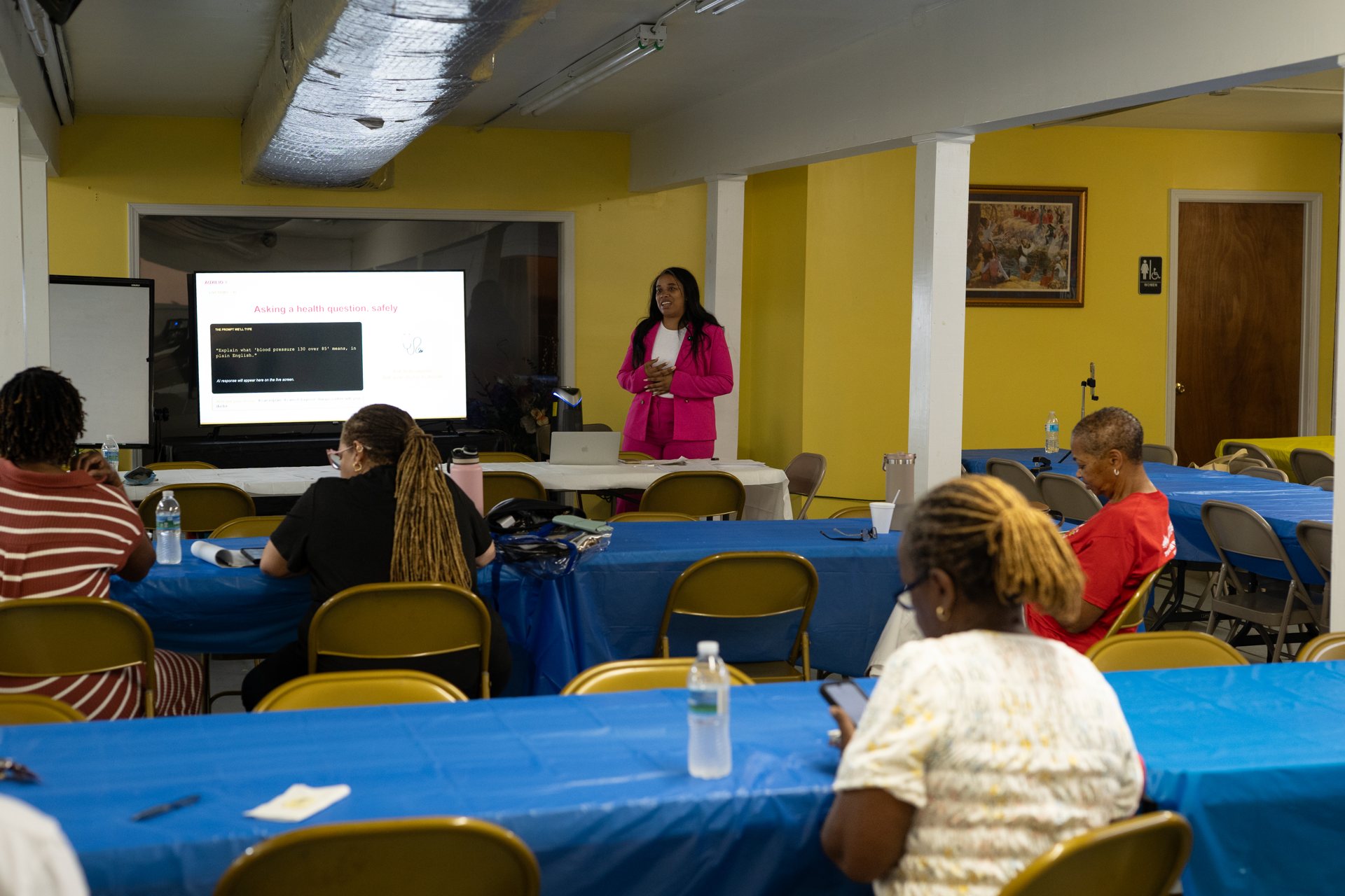Instructor helping a group of seniors learn to use their smartphones in a bright community classroom